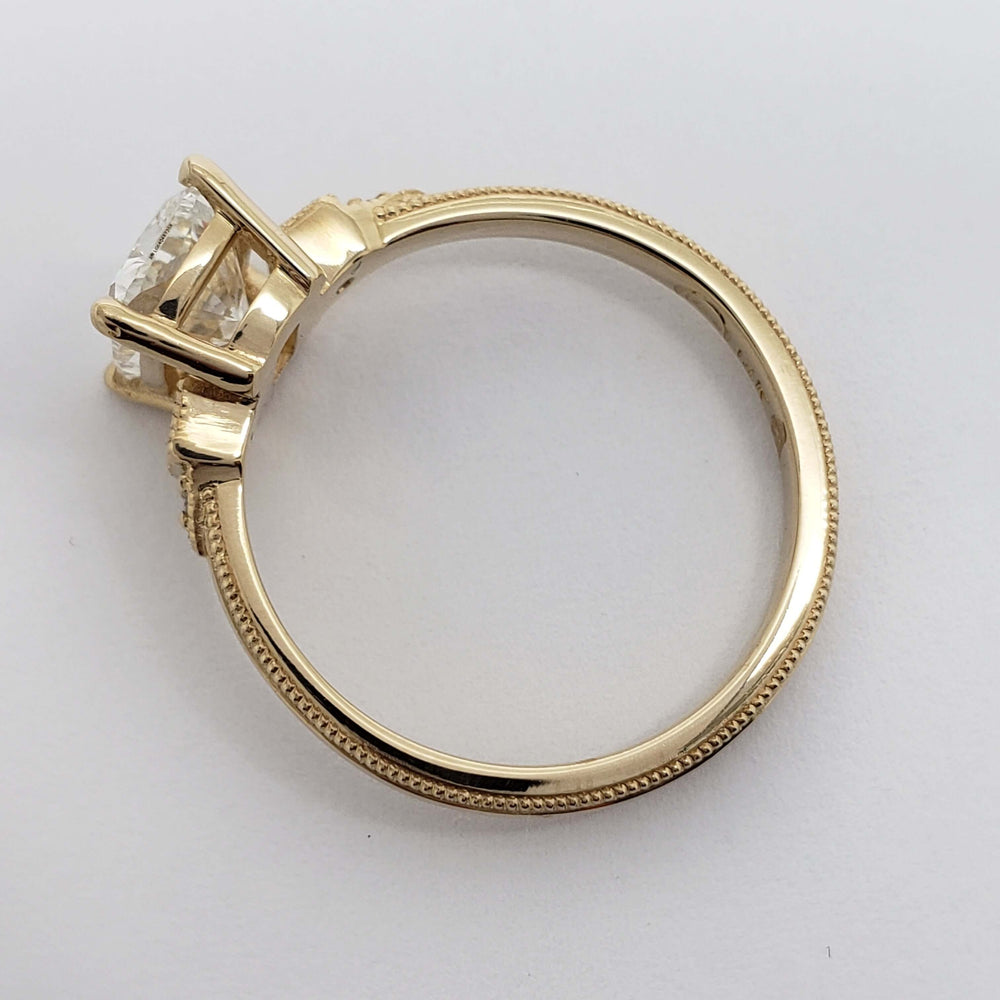 Profile of yellow gold engagement ring with detailed millgrain and lab diamond setting