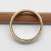 Side profile of 14kt yellow gold hammered wedding ring on a pencil