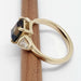 Profile view of 14kt yellow gold ring with emerald cut sapphire and trillion diamonds