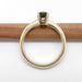 Profile view of 14kt yellow gold ring with green Tanzanian sapphire, band resting on pencil