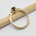 Side view of yellow gold ring with millgrain edge and openwork under bezel setting
