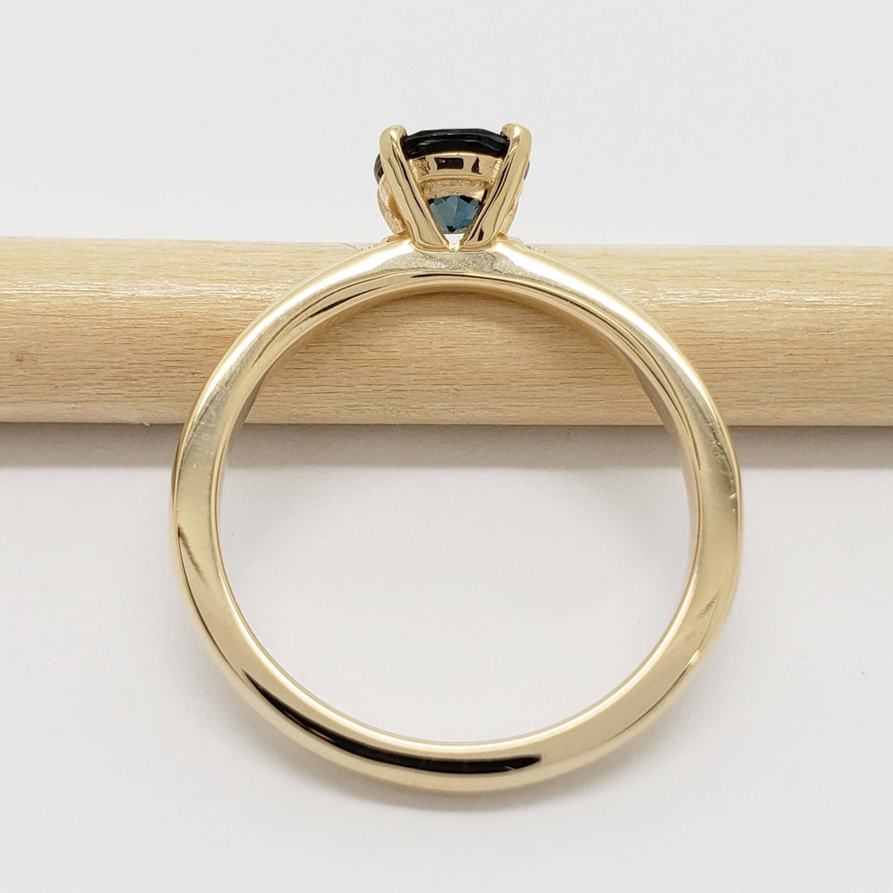 Side profile of yellow gold ring with teal Australian sapphire and diamond accents