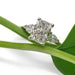 Radiant cut lab diamond three-stone ring in white gold resting on a green plant stem