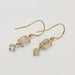 Back view of 14kt yellow gold dangle earrings with oval and round aquamarine gemstones
