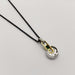 Back view of 18kt yellow and white gold pendant with emerald and diamonds on black chain