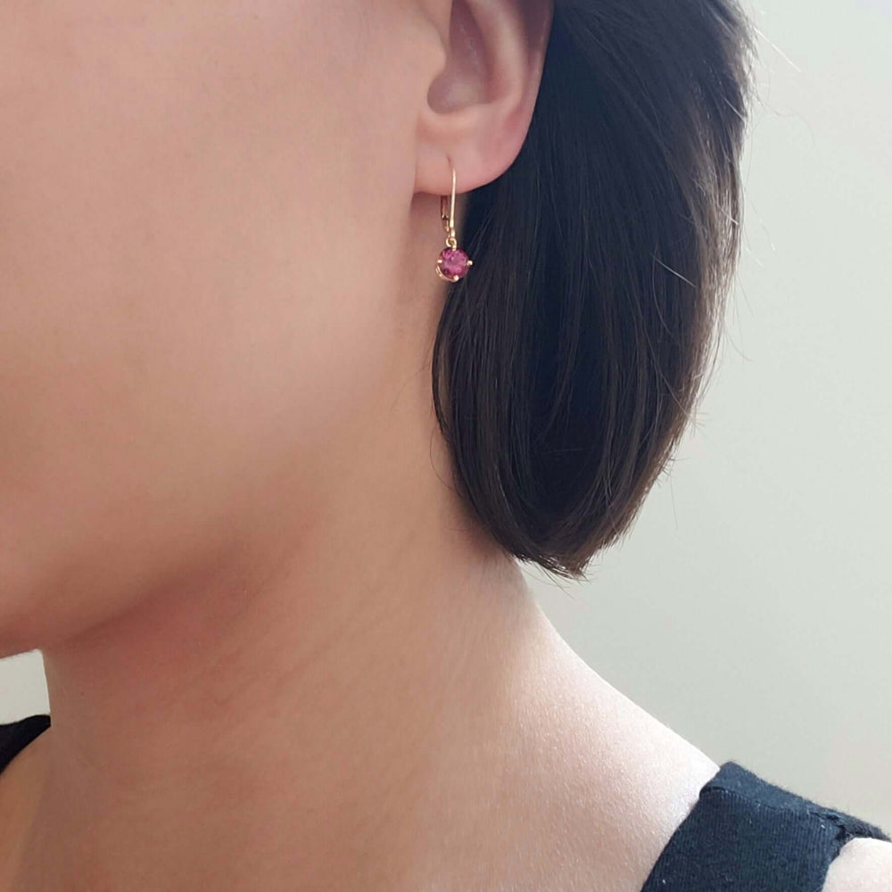 Rhodolite garnet and yellow gold drop earring worn on ear