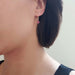 Rhodolite garnet and yellow gold drop earring worn on ear