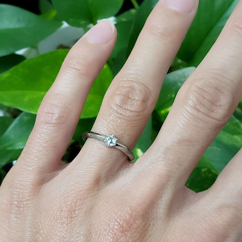 Rose cut diamond engagement ring in white gold shown on hand