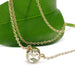 Bezel-set rose cut moissanite necklace in 14kt yellow gold displayed on a leaf