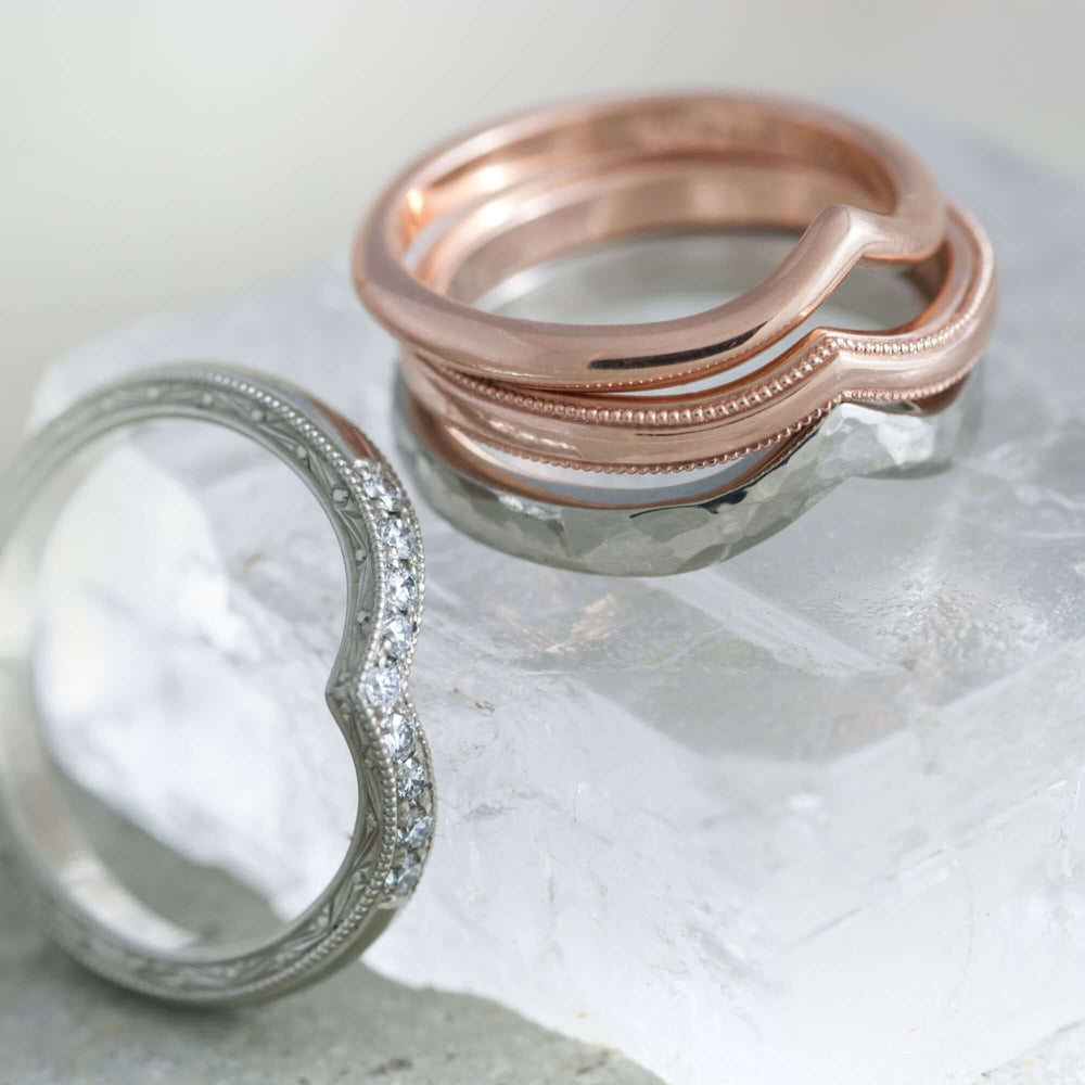 Stack of rose gold chevron rings with millgrain and white gold diamond band