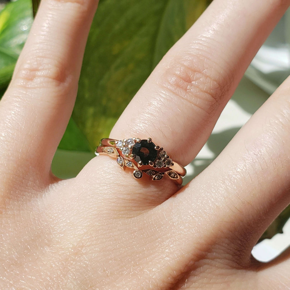 Rose gold diamond leaf wedding ring stacked with black gemstone engagement ring