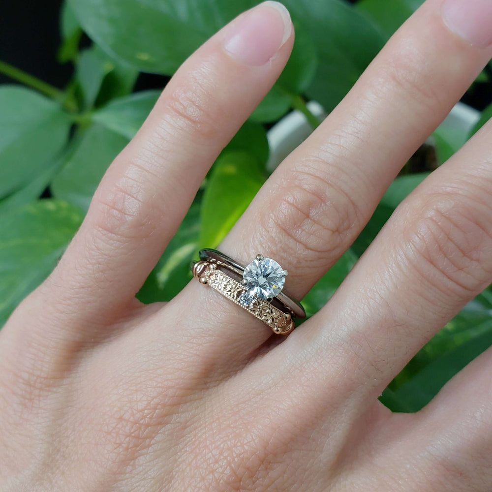 Rose gold engraved wedding ring with lab diamond stacked with solitaire engagement ring, on hand