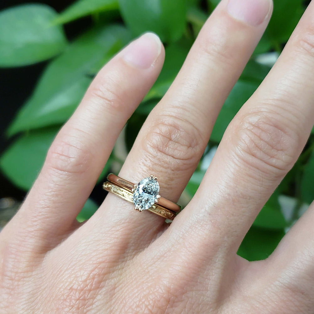 14kt rose gold lab diamond solitaire ring stacked with engraved and plain bands on hand