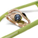 14kt rose gold leaf and twig wedding ring stacked with a blue gemstone engagement ring