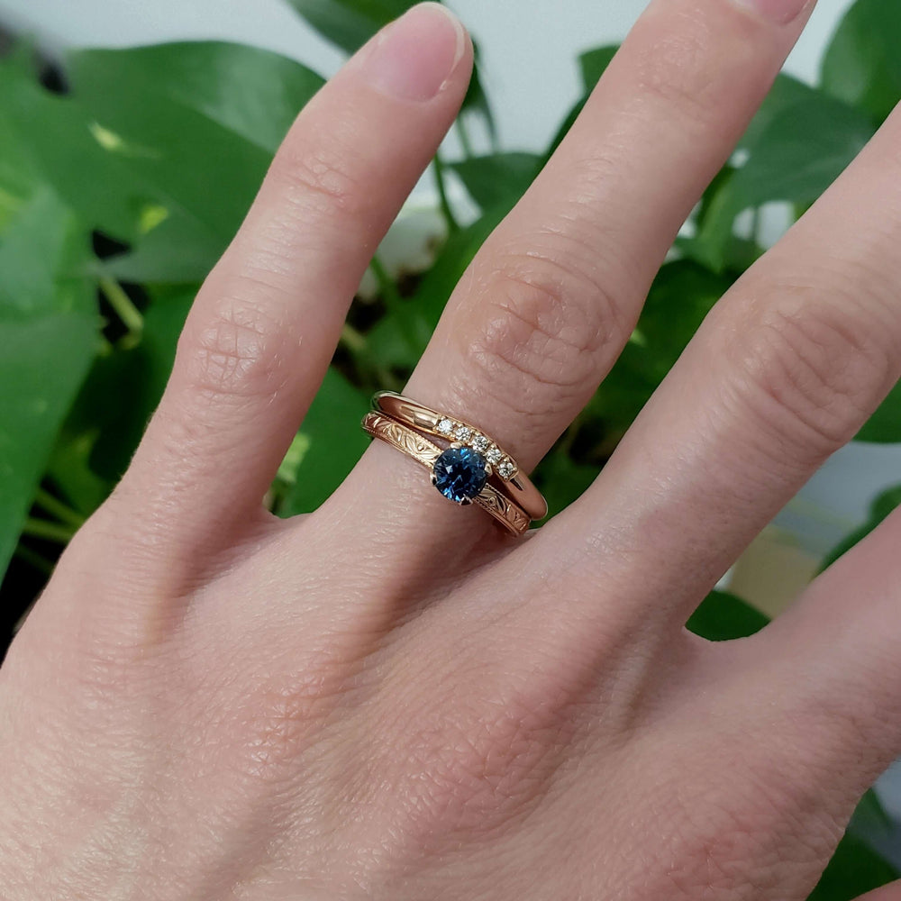 Rose gold sapphire engagement ring stacked with diamond band, worn on hand