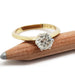 Round brilliant diamond solitaire ring in yellow gold with white gold prongs, on pencil