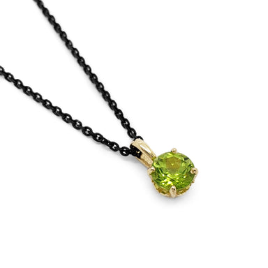 Round green peridot pendant in 14kt yellow gold filigree setting on black chain