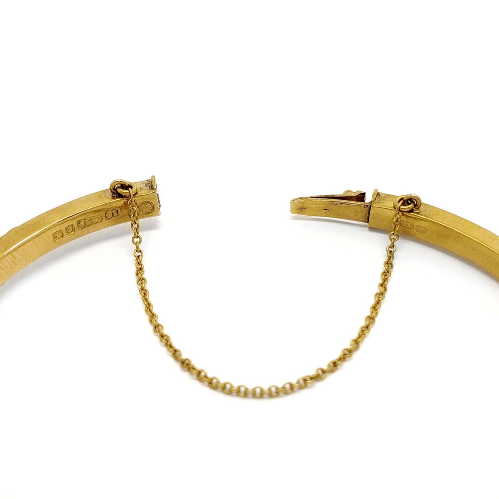 Detail of safety chain and hallmarks on open antique 15kt gold bangle