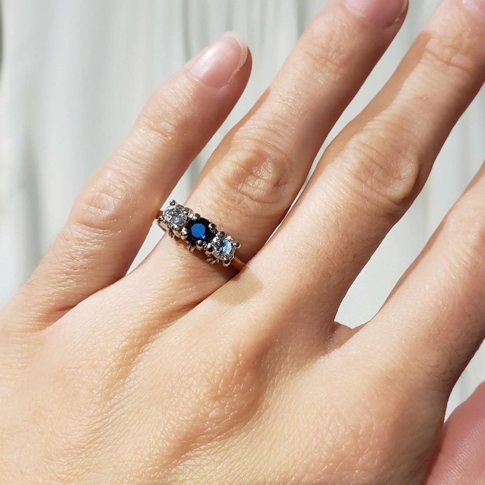 Sapphire and diamond three-stone ring in 14kt gold shown on a hand