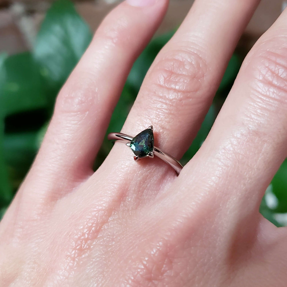 Shield cut green sapphire ring in white gold shown on hand