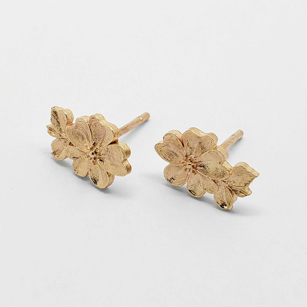 Side view of 14kt yellow gold floral rose stud earrings on white background