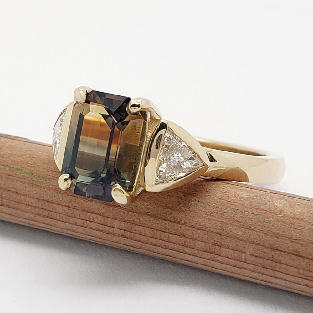 Side angle of bi-coloured sapphire and trillion diamond ring in 14kt yellow gold