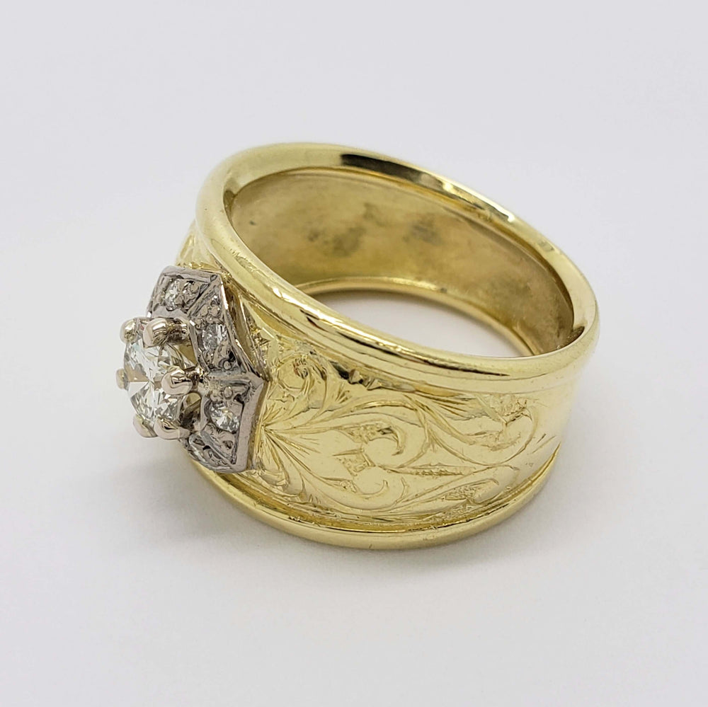 Side angle of engraved 18kt yellow gold ring with round diamond halo centerpiece