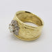 Side angle of engraved 18kt yellow gold ring with round diamond halo centerpiece