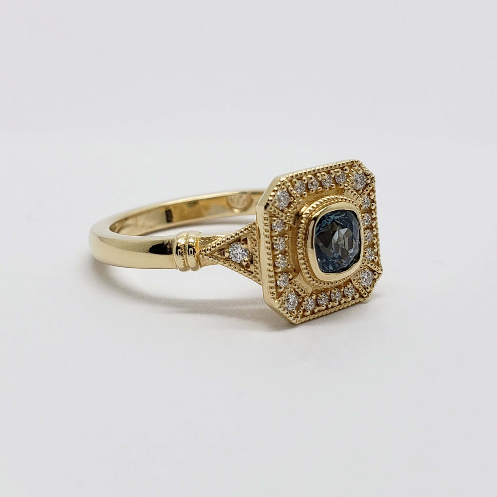Side angle of handcrafted yellow gold ring with Montana sapphire and pavé diamonds