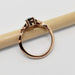 Side profile of 14k rose gold ring with teal sapphire and diamond leaf details