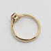 Side view of 14k yellow gold ring showing pink sapphire and hallmark
