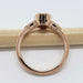 Side view of 14kt rose gold ring with cutout gallery and millgrain details, shown on a pencil
