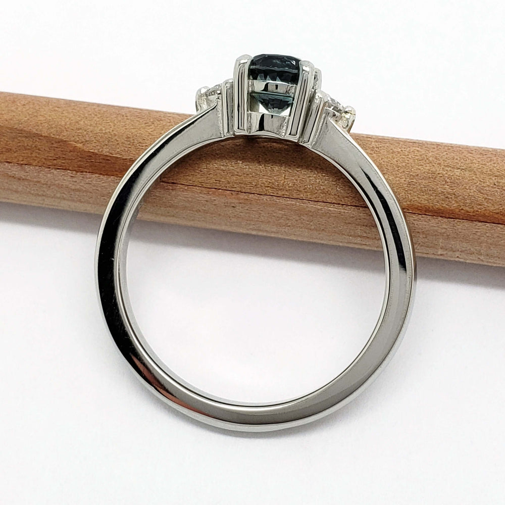 Side view of 14kt white gold Montana sapphire and diamond ring on white background