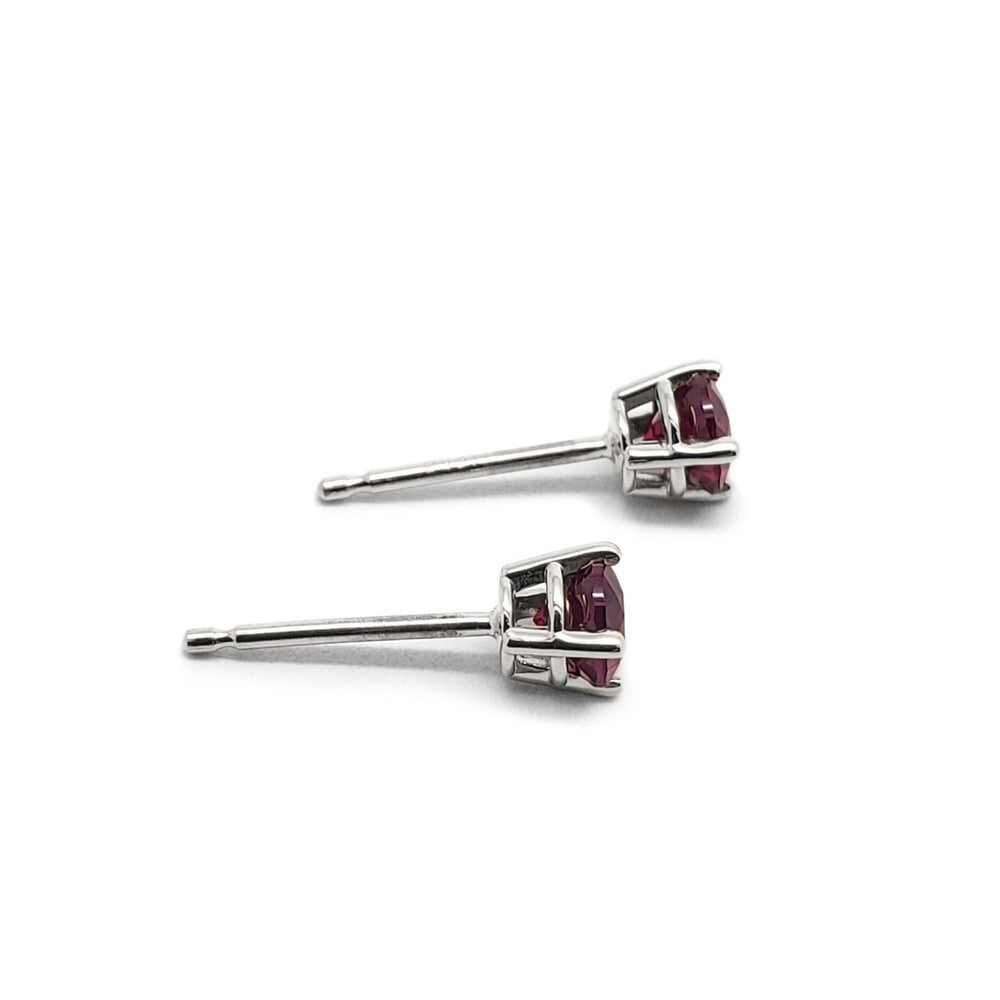Side view of 14kt white gold lab grown ruby stud earrings showing claw setting