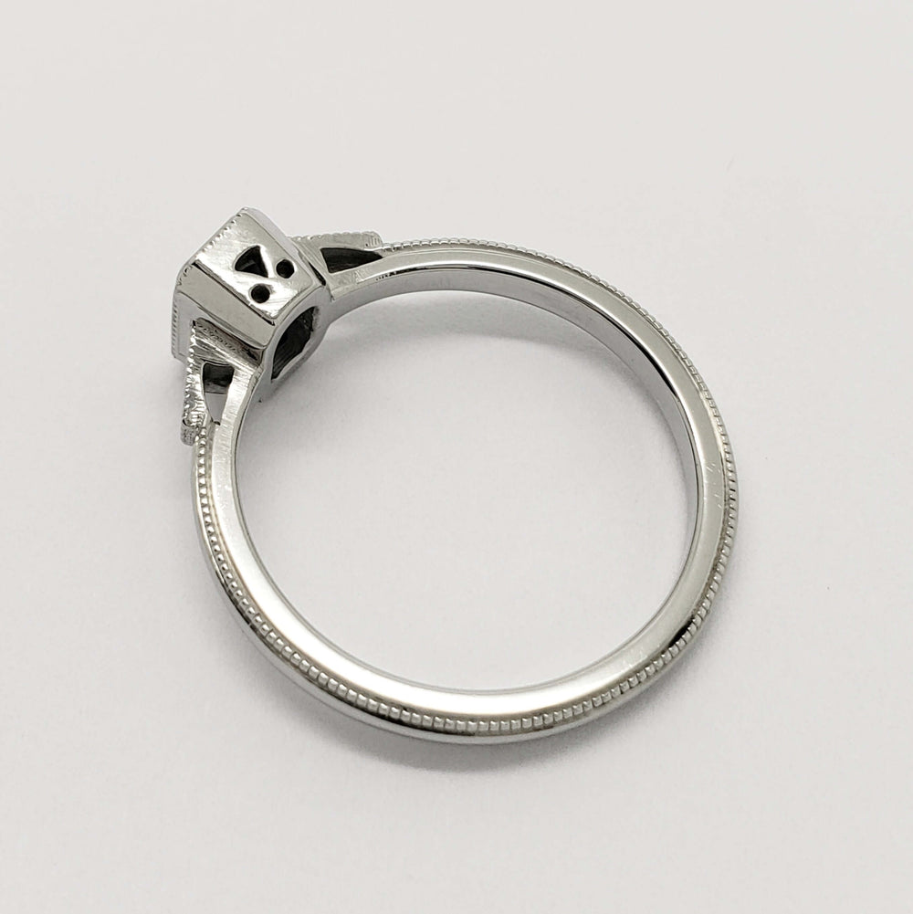 Side profile of 14kt white gold ring with milgrain detail and openwork under the setting