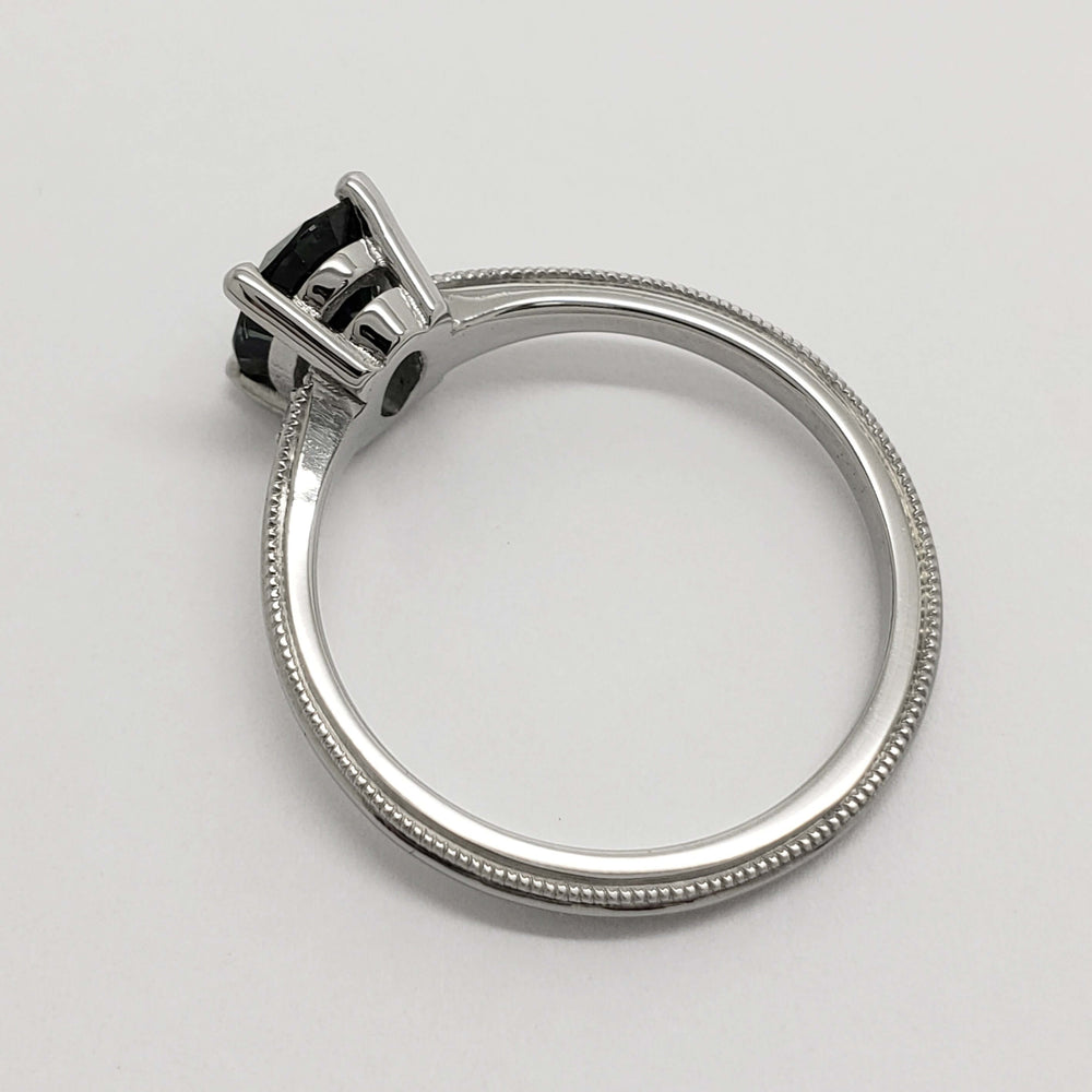 Side profile of 14kt white gold ring with milgrain detail and sapphire setting