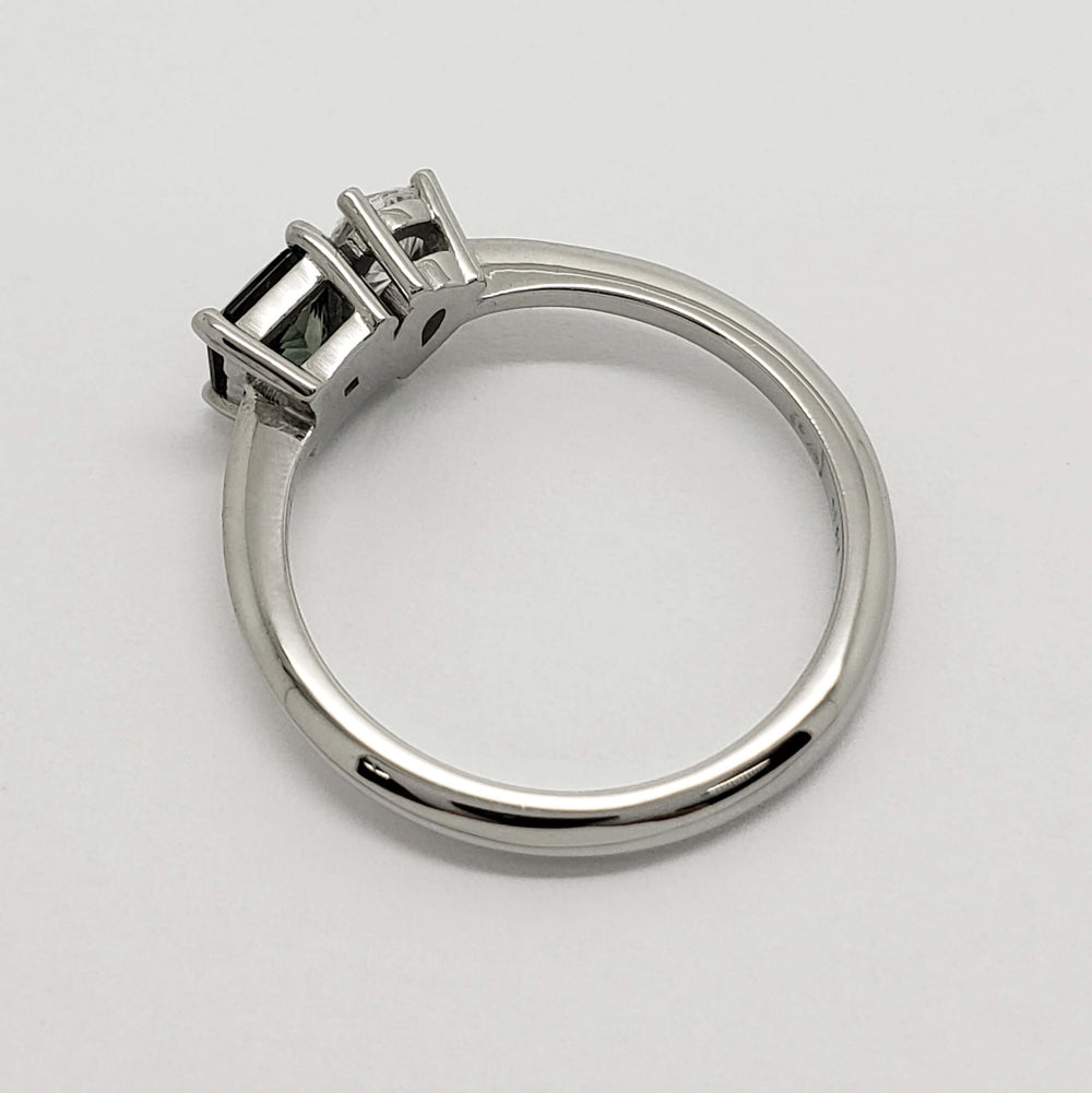 Side profile of 14kt white gold ring with teal sapphire and pear lab diamond settings