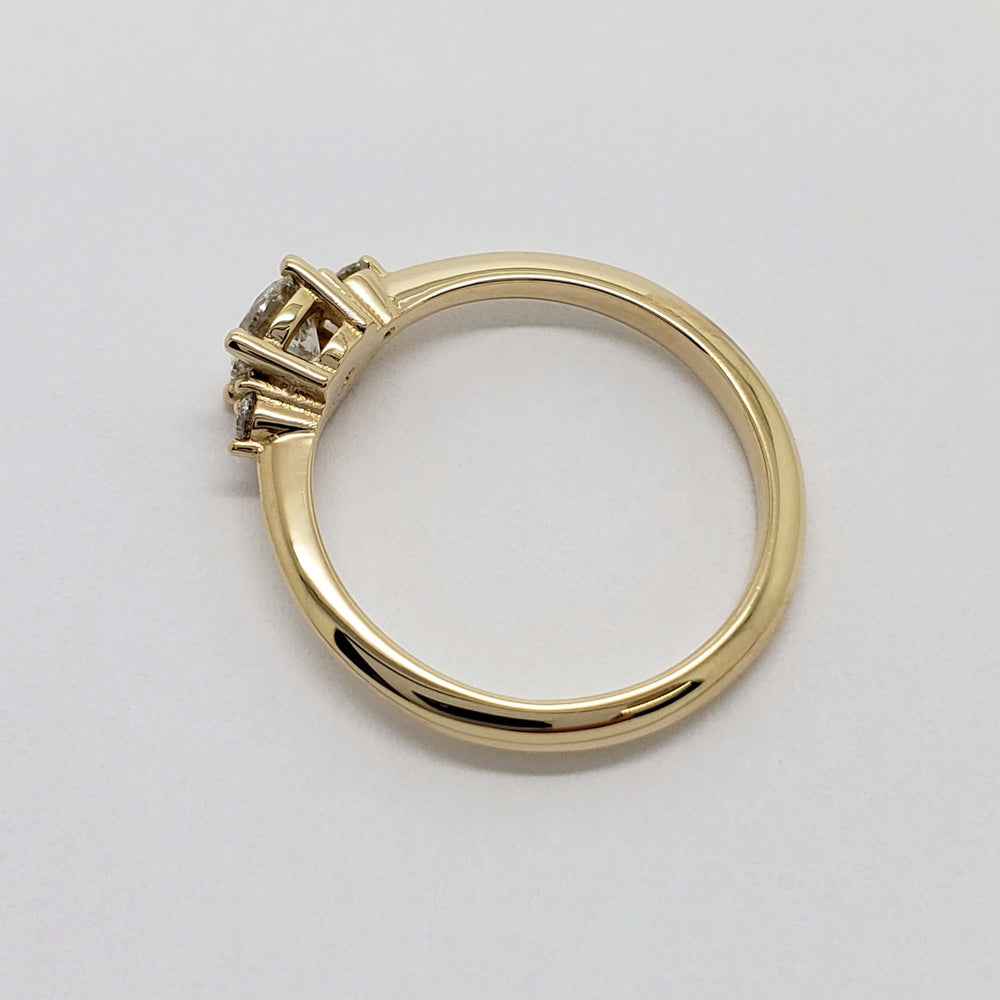 Side profile of 14kt yellow gold diamond engagement ring showing prong setting and band