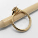 Side view of 14kt yellow gold engagement ring with millgrain and champagne diamond, on a pencil