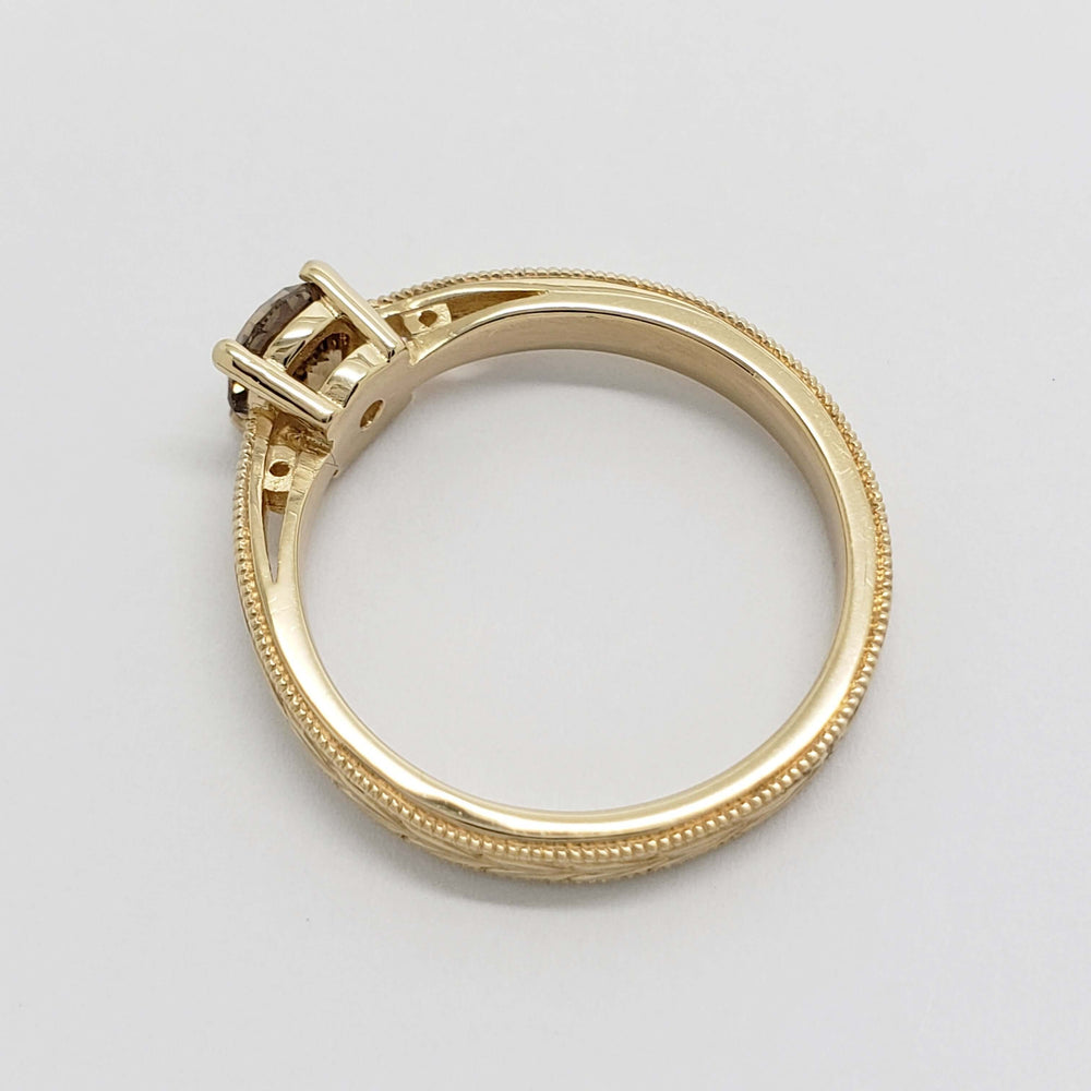 Side view of 14kt yellow gold ring with champagne diamond and detailed engraving