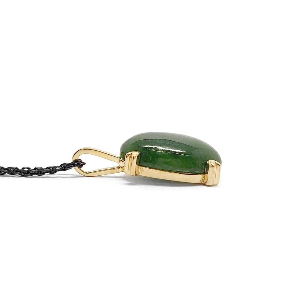 Profile view of 14kt yellow gold jade pendant with deep green cabochon