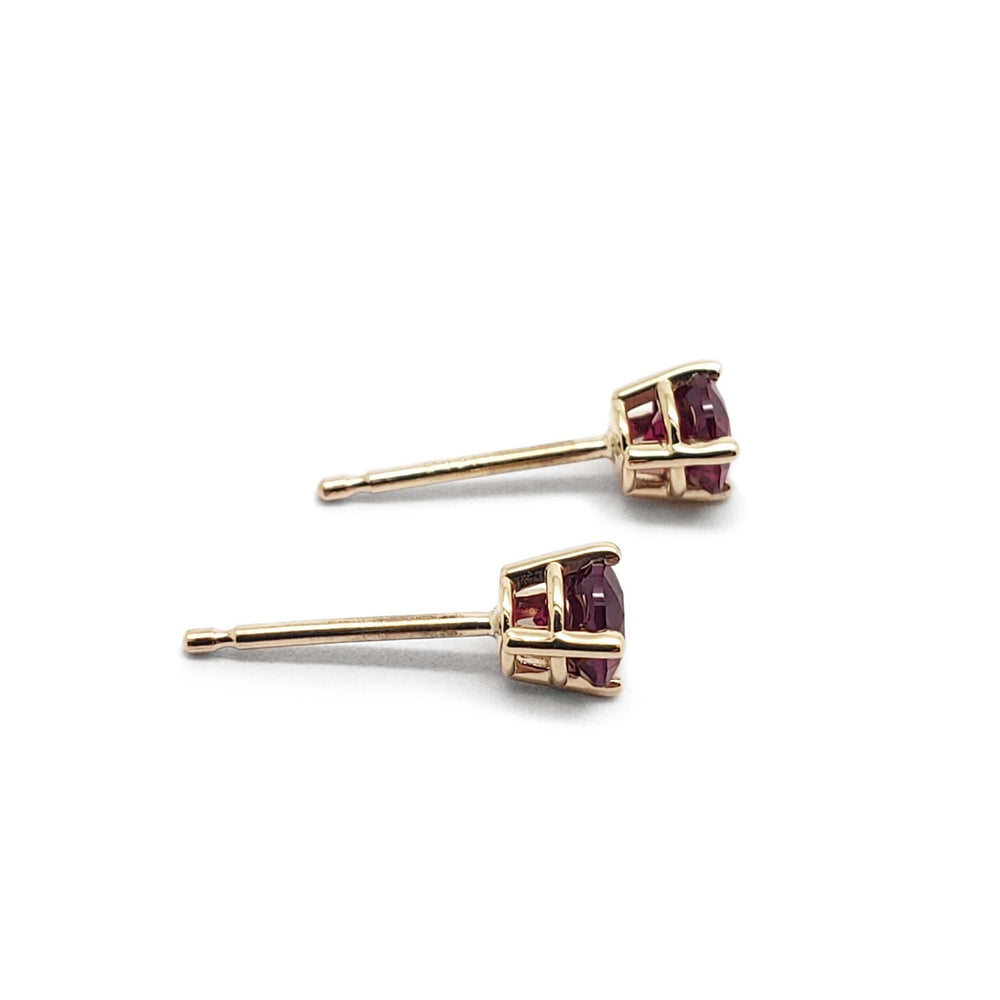 Side view of 14kt yellow gold lab grown ruby stud earrings showing claw setting