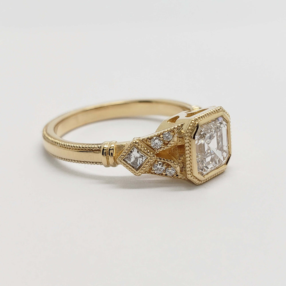 Side profile of 14kt yellow gold ring with asscher cut lab diamond and detailed millgrain