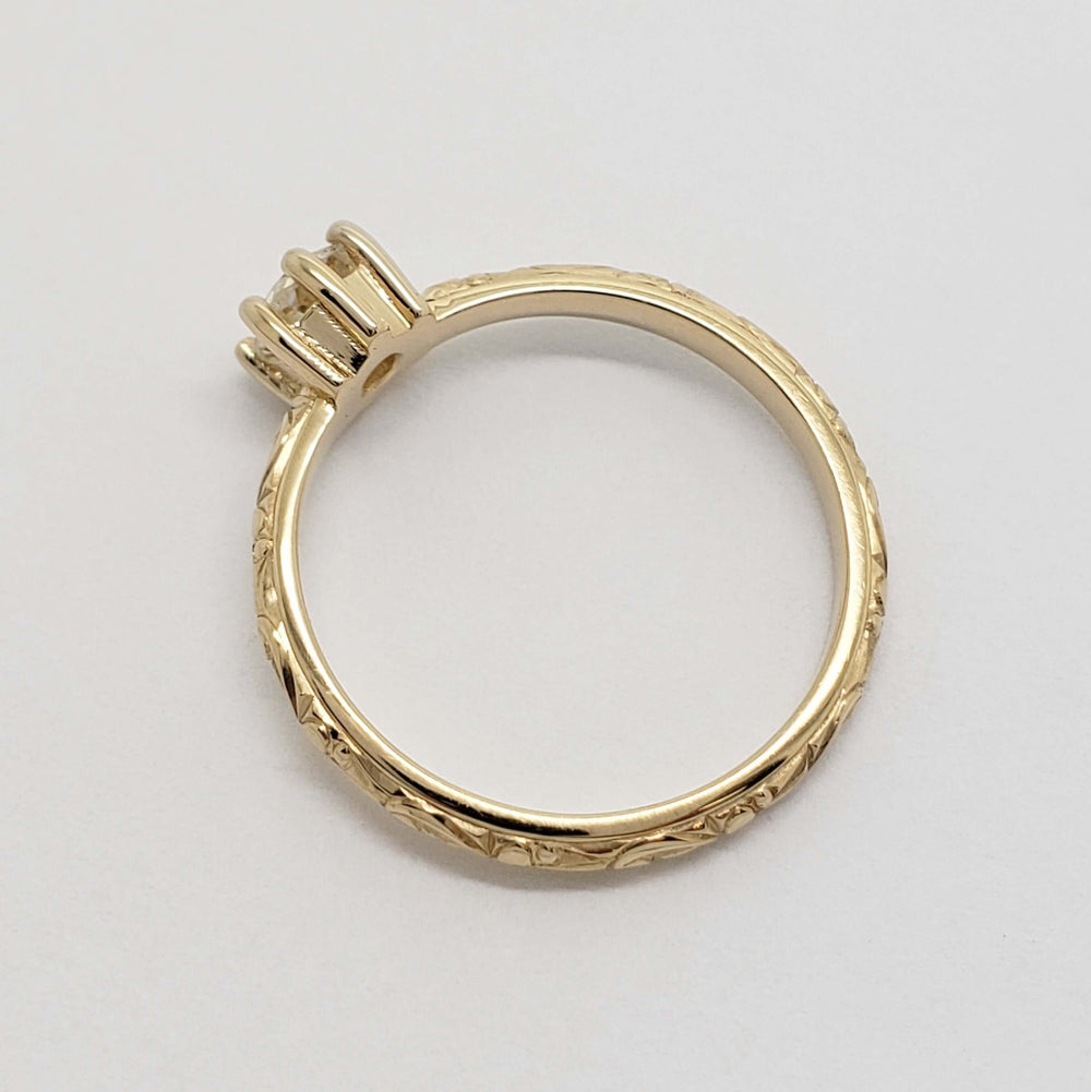 Side profile of engraved 14k yellow gold ring with antique diamond setting