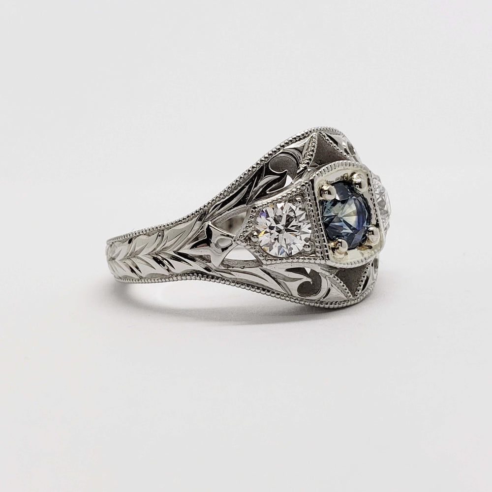 Side view of engraved 14kt white gold ring with blue sapphire and round diamonds