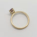 Side profile of engraved yellow gold ring with pink sapphire center stone