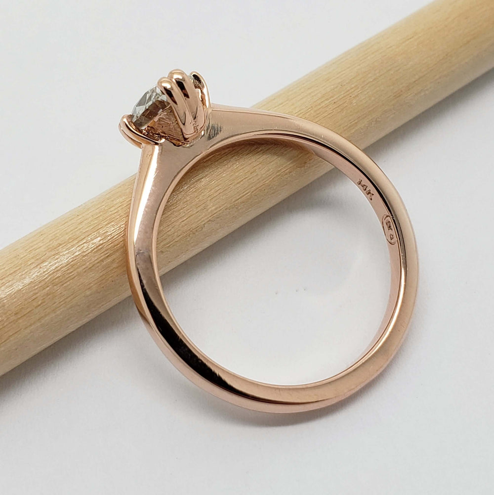 Side view of 14kt rose gold solitaire ring with oval lab diamond and hallmark stamp