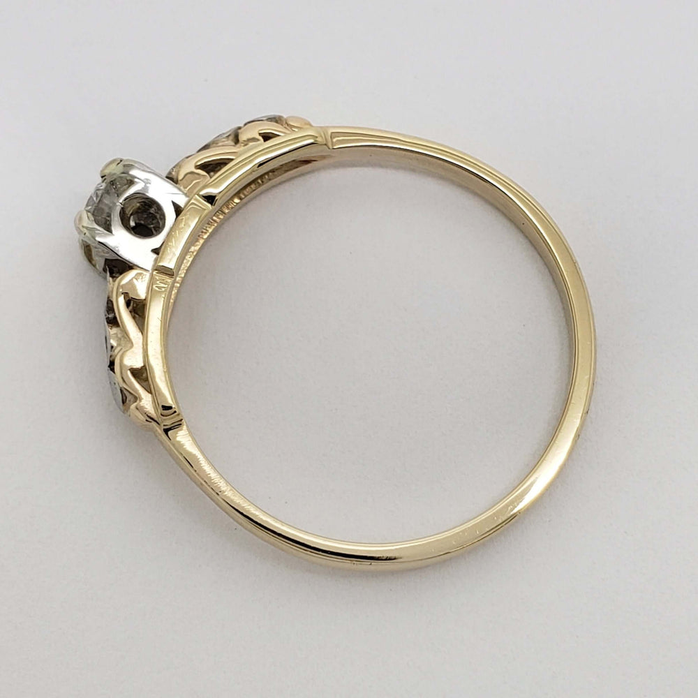 Side profile of two-tone gold antique diamond ring with openwork gallery