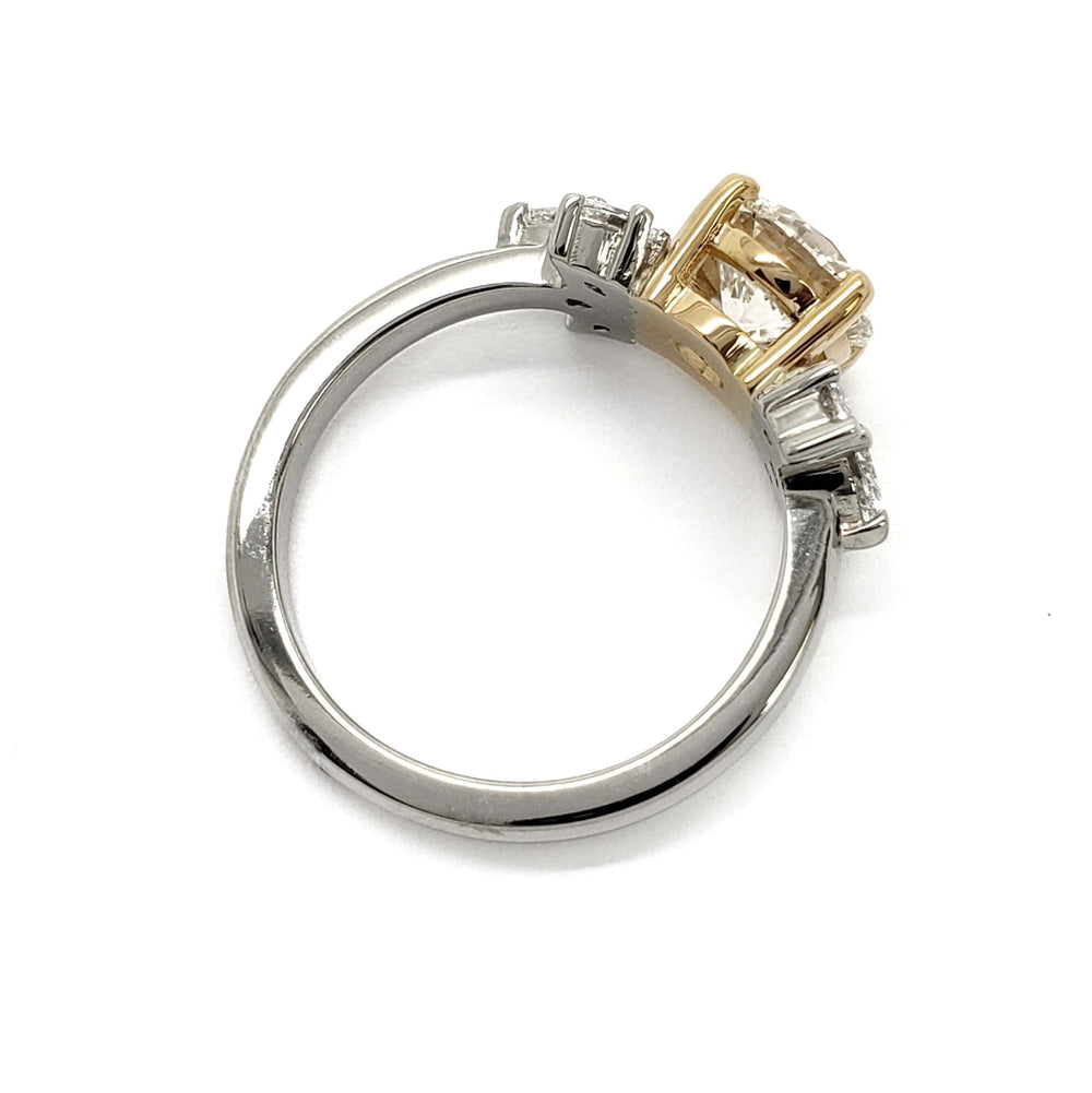 Side profile of two-tone gold engagement ring with round lab diamond and marquise diamond details