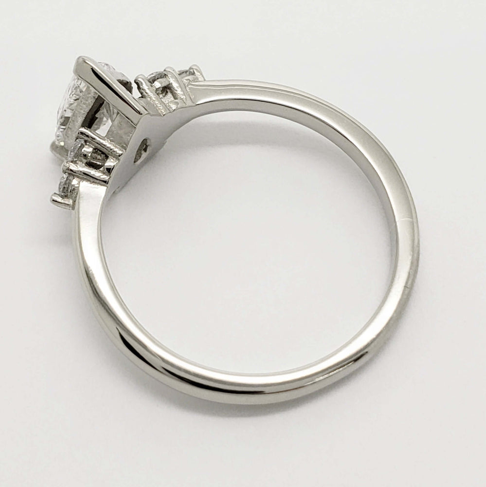 Side profile of white gold engagement ring with pear cut lab diamond and accent stones